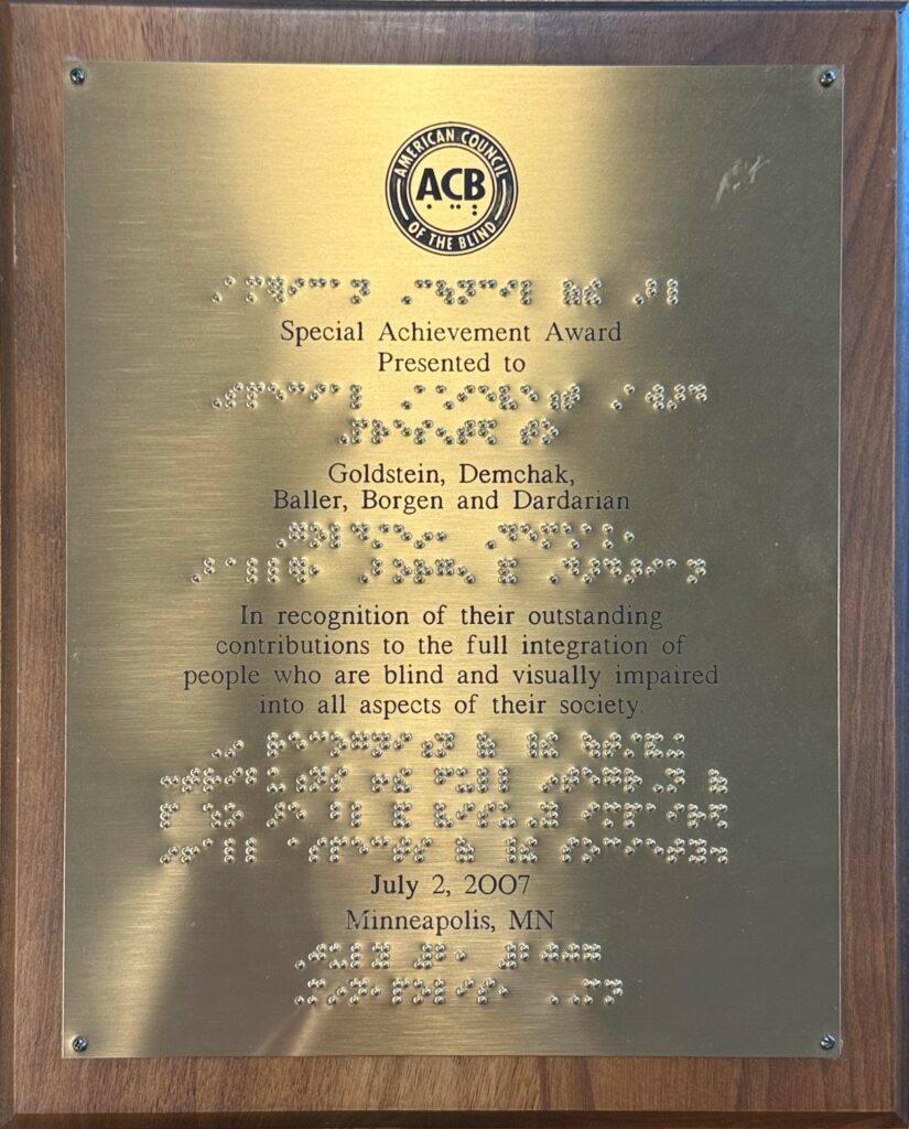 American Council of the Blind, 2007 Special Achievement Award Brass plaque mounted on wood, featuring embossed text and Braille. logo of ACB, American Council of the Blind, on top followed by text that reads: Special Achievement Award presented to Goldstein, Demchak, Baller, Borgen and Dardarian. Below that text reads: In recognition of their outstanding contributions to the full integration of people who are blind and visually impaired into all aspects of their society dated July 2, 2007, Minneapolis, MN.