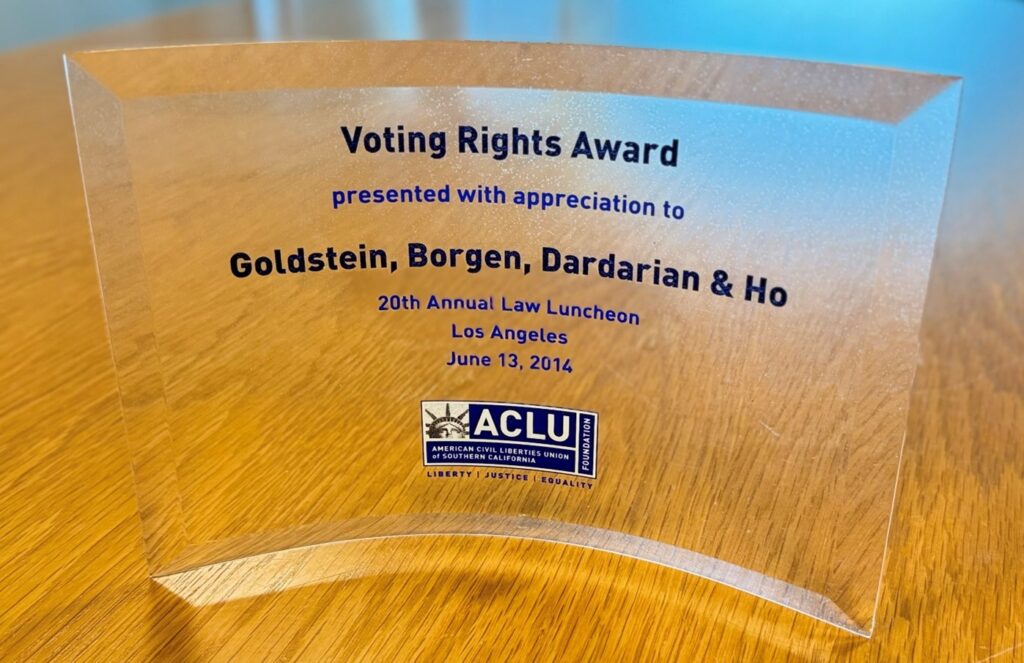 ACLU of SoCal, Voting Rights Awards, 2014 A photograph of a clear acrylic award plaque titled "Voting Rights Award" presented with appreciation to Goldstein, Borgen, Dardarian & Ho at the 20th Annual Law Luncheon in Los Angeles on June 13, 2014. The plaque features the ACLU logo with the words "Liberty, Justice, Equality" at the bottom, highlighting recognition for contributions to voting rights.