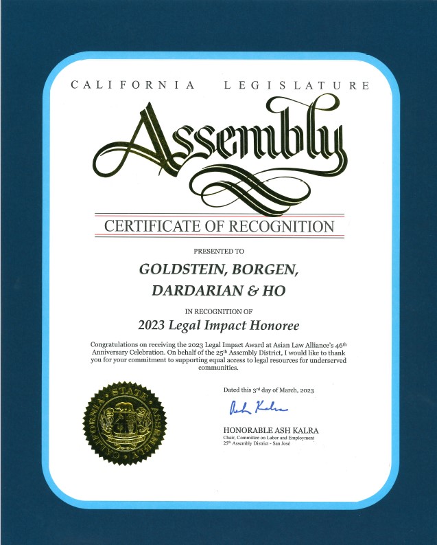 Asian Law Alliance California Legislature Assembly Certificate of Recognition, 2023 California Legislature Assembly Certificate of Recognition displayed against a dark blue background with a bright light-blue rounded border around the certificate. At the top of the white certificate, the text reads: CALIFORNIA LEGISLATURE Below it is a large, ornate, dark-green “Assembly” logo in calligraphic lettering, with elaborate flourishes extending beneath the word. A horizontal line appears beneath the logo, followed by: CERTIFICATE OF RECOGNITION with another horizontal line below it. Centered underneath is: PRESENTED TO GOLDSTEIN, BORGEN, DARDARIAN & HO Then: IN RECOGNITION OF 2023 Legal Impact Honoree The certificate continues with a paragraph stating: “Congratulations on receiving the 2023 Legal Impact Award at Asian Law Alliance’s 46th Anniversary Celebration. On behalf of the 25th Assembly District, I would like to thank you for your commitment to supporting equal access to legal resources for underserved communities.” Near the lower right, it says: Dated this 3rd day of March, 2023 Below that is a blue handwritten signature. The printed text underneath reads: HONORABLE ASH KALRA Chair, Committee on Labor and Employment 25th Assembly District - San José A gold-and-black embossed California State Assembly seal appears in the lower-left portion of the certificate. The certificate itself is predominantly white, with a rounded rectangular light-blue border and dark-blue outer background.
