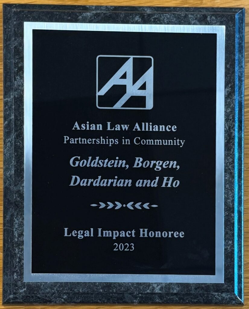 Asian Law Alliance, Legal Impact Honoree, 2023 Plaque awarded by Asian Law Alliance recognizing Goldstein, Borgen, Dardarian and Ho as Legal Impact Honoree for 2023. Features black background with silver text and logo, framed by a dark marble border. Award reads: Asian Law Alliance logo: AA written in italicized capital letters. Asian Law Alliance Partnerships in Community Goldstein, Borgen, Dardarian and Ho Legal Impact Honoree 2023